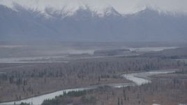 4K aerial stock footage flying over river valley, away from snowy Chugach Mountains, Knik River, Alaska Aerial Stock Footage | AK0001_0620