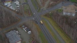 4K aerial stock footage tracking, passing school bus on Old Glenn Highway, tilt up to reveal Chugiak, Alaska Aerial Stock Footage | AK0001_0660