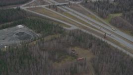 4K aerial stock footage following Glenn Highway, wooded area, by an overpass, Eagle River, Alaska Aerial Stock Footage | AK0001_0665