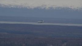 4K aerial stock footage tracking E-3 Sentry  landing, snowy mountains, Fort Richardson, Alaska Aerial Stock Footage | AK0001_0671