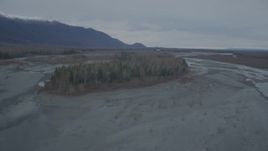 4K aerial stock footage fly over riverbed, tree lined island, during winter, Knik River, Alaska Aerial Stock Footage | AK0001_0697