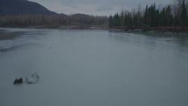 4K aerial stock footage flying low over river, approaching trees, shore, winter, Knik River, Alaska Aerial Stock Footage | AK0001_0703