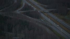 4K aerial stock footage flying by Glenn Highway through forest, during winter, Chugiak, Alaska Aerial Stock Footage | AK0001_0710