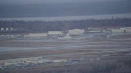 4K aerial stock footage flying by hangars, runway in winter, Elmendorf Air Force Base, Anchorage Aerial Stock Footage | AK0001_0740