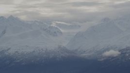 4K aerial stock footage flying by clouds, snow-covered Chugach Mountains, Alaska Aerial Stock Footage | AK0001_0791