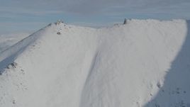 4K aerial stock footage flying low over snowy ridge, revealing Chugach Mountains, Alaska Aerial Stock Footage | AK0001_0796