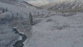 4K aerial stock footage flying low beside river, frosty valley, snowy Chugach Mountains, Alaska Aerial Stock Footage | AK0001_0803