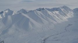 4K aerial stock footage flying over ridge, reveal valley, snowy Chugach Mountains, Alaska Aerial Stock Footage | AK0001_0819