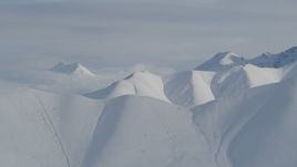 4K aerial stock footage flying by snow-covered ranges, low clouds, Chugach Mountains, Alaska Aerial Stock Footage | AK0001_0820