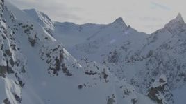 4K aerial stock footage flying by rocky, snow-covered slopes, approach Chugach Mountains, Alaska Aerial Stock Footage | AK0001_0826