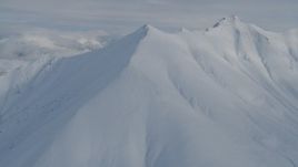 4K aerial stock footage approaching snowy range, cloudy, Chugach Mountains, Alaska Aerial Stock Footage | AK0001_0836