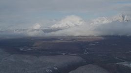4K aerial stock footage flying by Talkeetna Mountains, clouds, and Matanuska River Valley, Alaska in winter Aerial Stock Footage | AK0001_0848