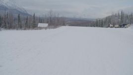 4K aerial stock footage flying low over snowy runway at King Ranch, and reveal Matanuska River Valley, Sutton, Alaska Aerial Stock Footage | AK0001_0864