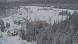 4K aerial stock footage orbiting snowy King Ranch, descend to runway, landing, Sutton, Alaska Aerial Stock Footage | AK0001_0865