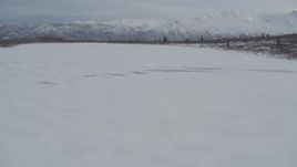 4K aerial stock footage flying low over snow-covered frozen Goober Lake, Alaska Aerial Stock Footage | AK0001_0890