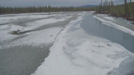 4K aerial stock footage flying low over the icy, snow covered river during winter in the Tazlina River Valley, Alaska Aerial Stock Footage | AK0001_0897