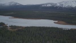 4K aerial stock footage flying over lake surrounded by forest during winter, Saint Anne Lake, Alaska Aerial Stock Footage | AK0001_0965