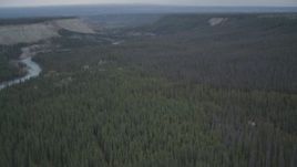 4K aerial stock footage fly over edge of cliff, during winter, revealing forest, and the Klutina River, Alaska Aerial Stock Footage | AK0001_0971