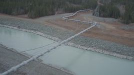4K aerial stock footage follow pipeline spanning Tazlina River during winter, Trans-Alaska Pipeline, Alaska Aerial Stock Footage | AK0001_1009