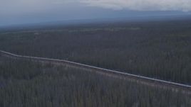 4K aerial stock footage flying over a snow covered lake and forest revealing Trans-Alaska Pipeline, Alaska Aerial Stock Footage | AK0001_1013