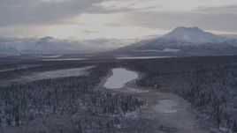 4K aerial stock footage flying over snow covered forest toward Long Lake, Alaska Aerial Stock Footage | AK0001_1053