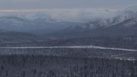 4K aerial stock footage snow capped Talkeetna Mountains and wooded foothills, Alaskan Wilderness Aerial Stock Footage | AK0001_1054