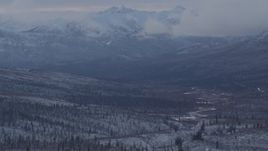 4K aerial stock footage snow covered, forested hills beneath low clouds, Alaskan Wilderness Aerial Stock Footage | AK0001_1056