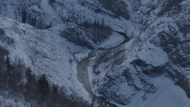 4K aerial stock footage following a river in a snow covered canyon, Talkeetna Mountains, Alaska Aerial Stock Footage | AK0001_1066