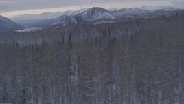 4K aerial stock footage flying over snow covered, wooded hills toward Matanuska River Valley, Alaska Aerial Stock Footage | AK0001_1090