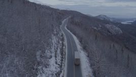 4K aerial stock footage following a truck on Glenn Highway, near Sutton, in snow, at twilight, Alaska Aerial Stock Footage | AK0001_1103