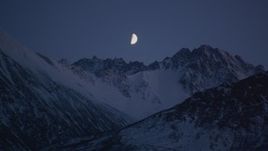 4K aerial stock footage the moon over the snow covered Chugach Mountains at night, Alaska Aerial Stock Footage | AK0001_1105