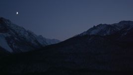 4K aerial stock footage the moon over the snow covered Chugach Mountains at night, Alaska Aerial Stock Footage | AK0001_1111