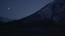 4K aerial stock footage the moon over the snow covered Chugach Mountains at night, Alaska Aerial Stock Footage | AK0001_1112