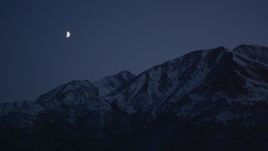 4K aerial stock footage the moon over the snow covered Chugach Mountains at night, Alaska Aerial Stock Footage | AK0001_1117