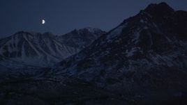 4K aerial stock footage the moon over the snow covered Chugach Mountains at night, Alaska Aerial Stock Footage | AK0001_1119