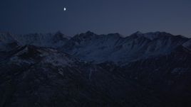 4K aerial stock footage the moon over the snow covered Chugach Mountains at night, Alaska Aerial Stock Footage | AK0001_1121