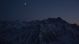 4K aerial stock footage the moon over the snow covered Chugach Mountains at night, Alaska Aerial Stock Footage | AK0001_1133