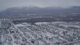 4K aerial stock footage panning across snow covered neighborhoods, reveal Glenn Highway, Anchorage, Alaska Aerial Stock Footage | AK0001_1149