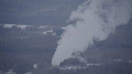 4K aerial stock footage a power plant, tilting up in plumes of steam, Anchorage, Alaska in snow Aerial Stock Footage | AK0001_1150