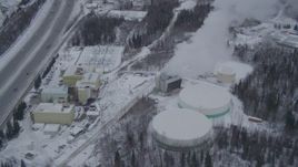 4K aerial stock footage tilting down on a snow covered power plant in Anchorage, Alaska Aerial Stock Footage | AK0001_1152