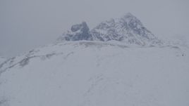 4K aerial stock footage tilting up a snowy slope revealing a peak in the Chugach Mountains, Alaska Aerial Stock Footage | AK0001_1177