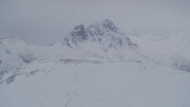 4K aerial stock footage flying toward rocky, snow covered Chugach Mountain peak, Alaska Aerial Stock Footage | AK0001_1178