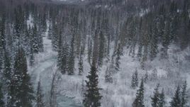 4K aerial stock footage flying over snowy, wooded valley revealing river, Chugach Mountains, Alaska Aerial Stock Footage | AK0001_1193