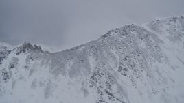4K aerial stock footage wind blowing snow off summit of a mountain range, Chugach Mountains, Alaska Aerial Stock Footage | AK0001_1207