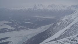 4K aerial stock footage Butte and Knik River Valley at base of snow covered Chugach Mountains, Alaska Aerial Stock Footage | AK0001_1210