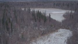 4K aerial stock footage flying over snow covered forest and lake in the Knik River Valley, Alaska Aerial Stock Footage | AK0001_1221