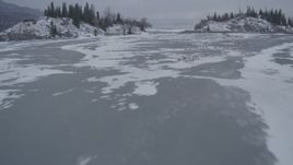 4K aerial stock footage flying over Knik River Valley between two snow covered, wooded hills, Alaska Aerial Stock Footage | AK0001_1256