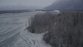 4K aerial stock footage ascending over trees and snow covered ground, Knik River Valley, Alaska Aerial Stock Footage | AK0001_1295