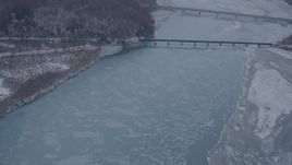 4K aerial stock footage fly over snowy shore, Glenn Highway, Highway 1 bridge, Knik River Valley, Alaska Aerial Stock Footage | AK0001_1301