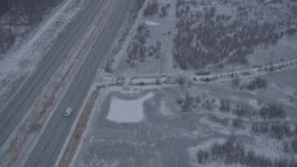 4K aerial stock footage following Glenn Highway through falling snow, Anchorage, Alaska Aerial Stock Footage | AK0001_1306